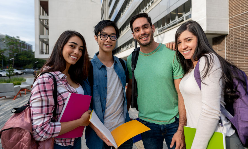 Estudiantes sonriendo afuera de edificio