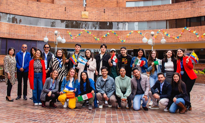 Grupo de estudiantes de intercambio sonriendo y sosteniendo banderas