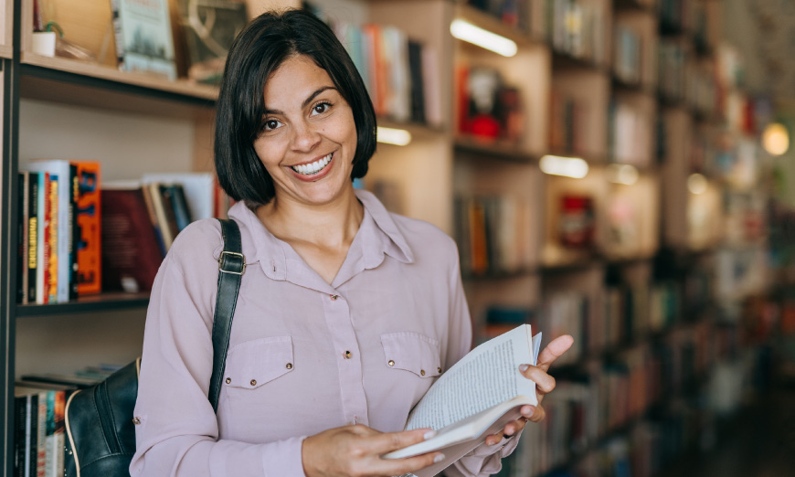 Profesora sonriendo con libro en la mano