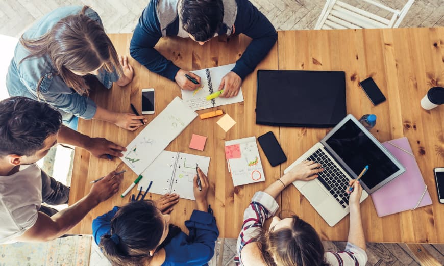 Estudiantes reunidos en mesa de trabajo