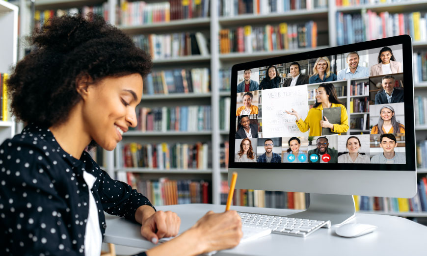 Mujer escribiendo mientras está en clase virtual